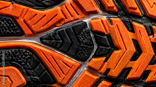 Extreme macro texture of complex bright orange and black running shoe rubber tread