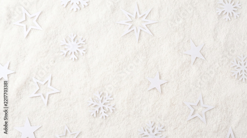 White christmas background with paper stars and snowflakes on snow