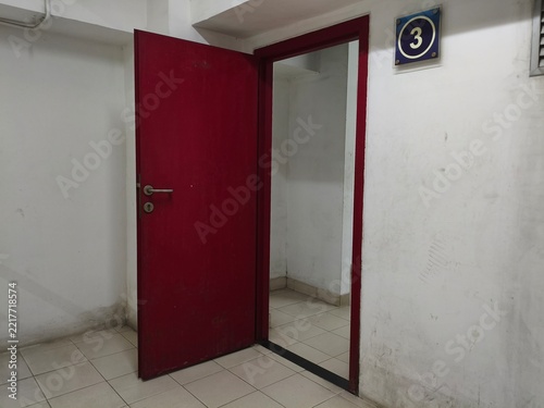 Open Red Door Leading Into Empty White Room with Number Three Sign