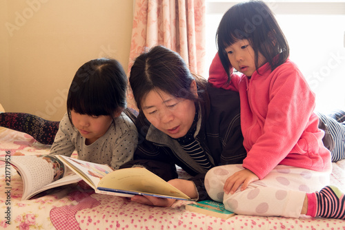 冬の家のリビングで読書する親子たちの姿