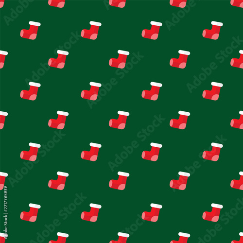 Christmas stocking seamless pattern background with red socks on green for holiday wrapping paper design