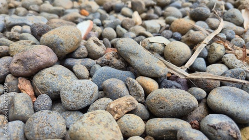 Fotografie Close-up top view of smooth river stones and gravel pebbles texture on ground