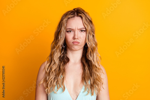Obraz na plátně Young blonde woman with pouty angry expression on yellow background, studio port
