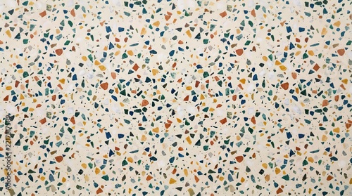 Speckled chips of blue and green and orange and cream fill a polished terrazzo surface. Retro interior material for design backgrounds.