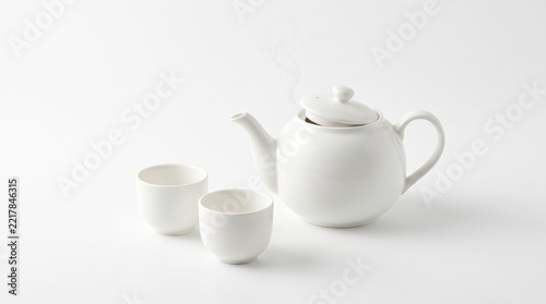 Minimalist White Ceramic Tea Set Featuring A Steaming Teapot And Two Small Cups On A Clean Bright Background