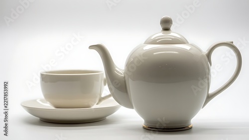 Minimalist white ceramic teapot with matching cup and saucer on plain background representing simplicity elegance and tea culture