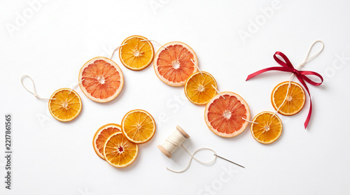 Dried citrus garland with red bow isolated on white background.