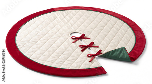 Quilted tree skirt with red bows isolated on white background.