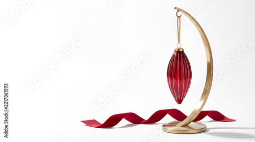 Red ornament on a curved gold stand isolated on white background with copy space.