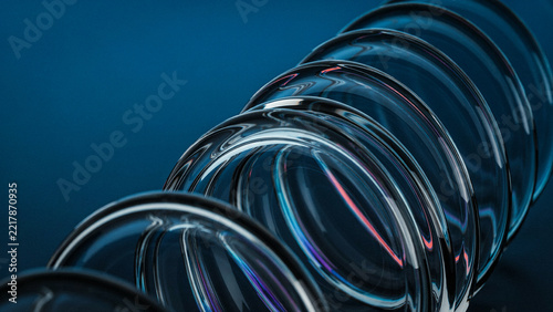 Abstract row of circular glass rings arranged in a diagonal line on blue background