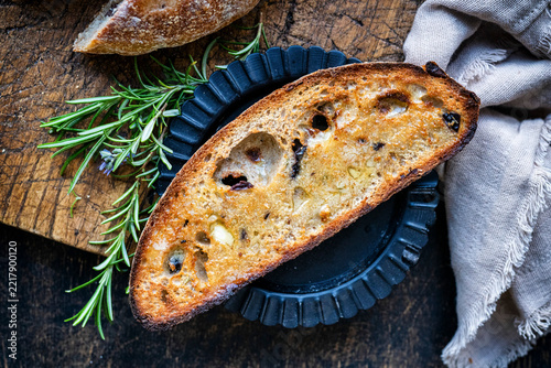 Toasted sourdough olive bread on a black plate