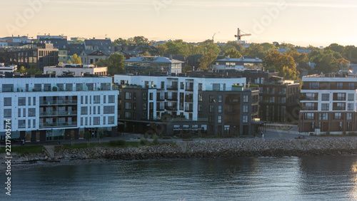 Contemporary waterfront apartment buildings by the sea in Kalaranna district, Tallinn, aerial telephoto view with autumn trees