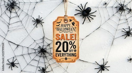 Happy Halloween Sale 20 percent on everything vintage price tag with string surrounded by spiders and cobwebs on white texture for spooky holiday store promotion discount