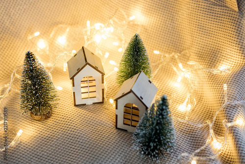 Cozy Christmas village with wooden miniature houses and fairy lights.