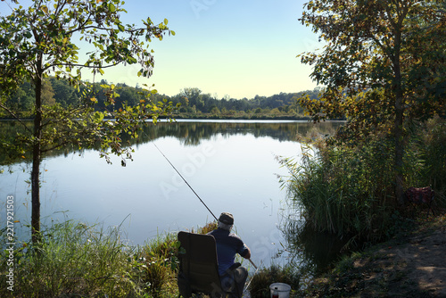 Pêcheur à la ligne vu de dos à l'étang