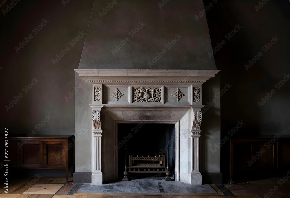 Naklejka premium Luxury interior design and home comfort, ornate stone fireplace in a dark moody living room with vintage wooden cabinets and classic architectural style