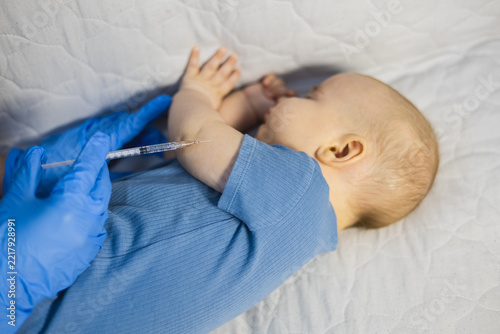 Close up of healthcare worker vaccinating an infant arm with a syringe in medical centre.