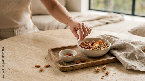 Woman's hand reaching healthy snacks from ceramic bowl