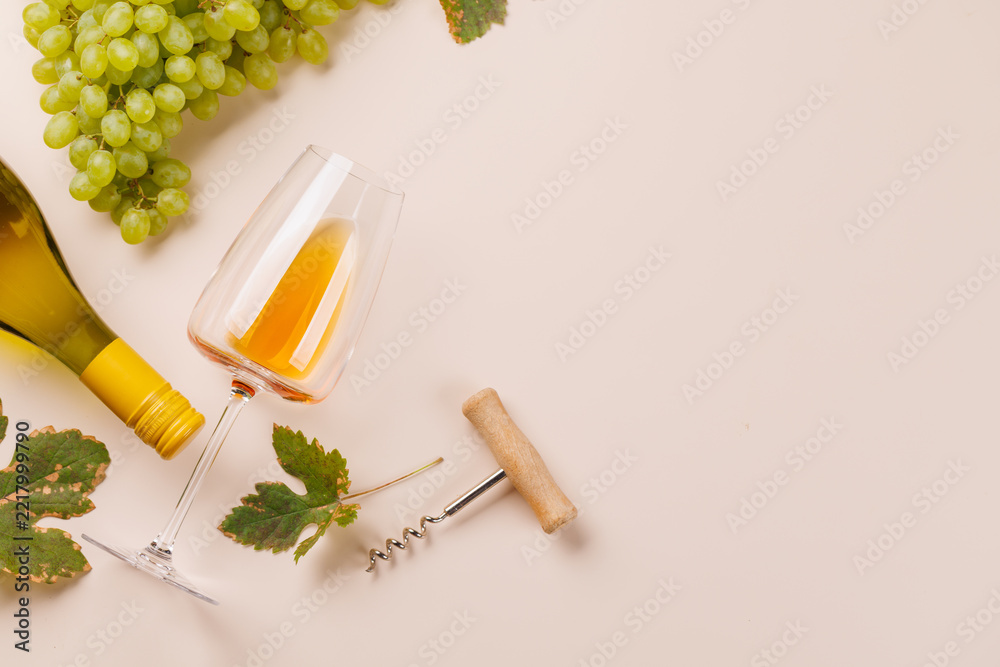 Fototapeta premium White wine bottle corkscrew and vine leaves - flat lay