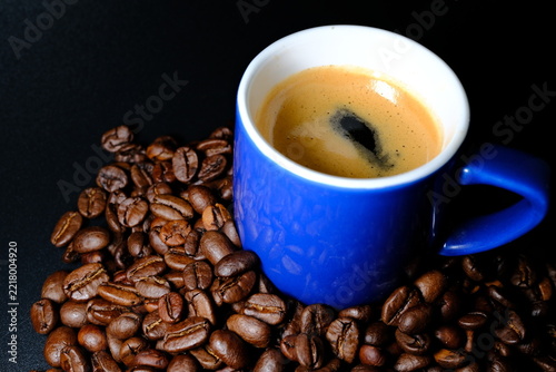 Fotografie Espresso coffee in blue cup surrounded by roasted coffee beans