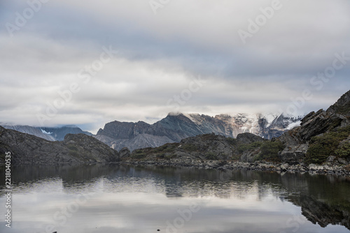 Serene alpine lake with snow-capped peaks reflection