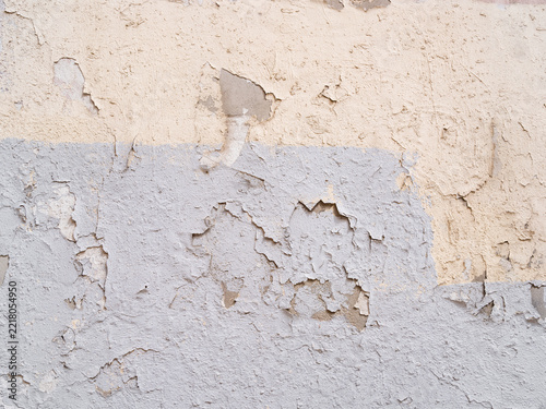 Grobe verputzte Wand oder Mauer mit Abplatzungen, gestrichen in den Farben beige und blau  als Hintergrund