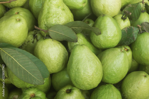 Many fresh guava fruits with leaves	