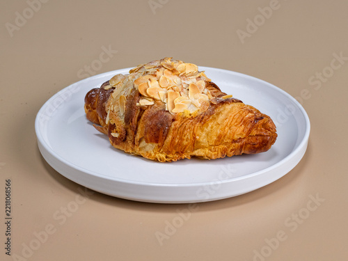 Golden almond croissant on a white plate