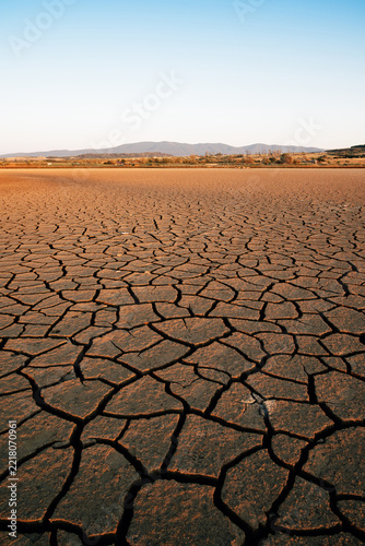 Climate change consequences with dried lake at sunset