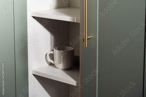 Coffee mug in home cabinet shelf
