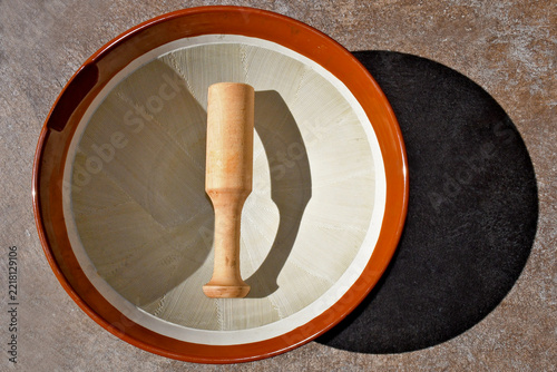 A traditional Japanese ceramic grinding bowl called a  suribachi with an interior surface of fine, jagged grooves (kushime) and pestle 