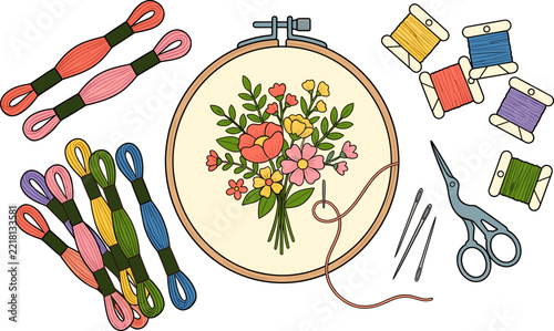 Embroidery hoop with floral design, colorful threads, needles, and scissors