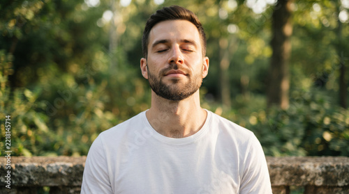 Man with beard meditating outdoors in nature with closed eyes