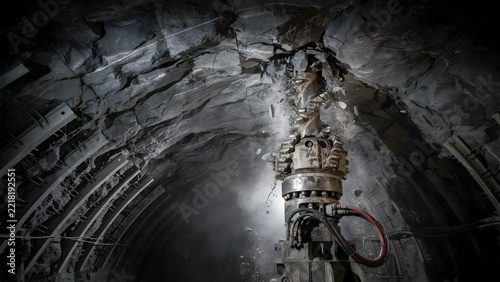 Underground mining tunnel with drilling equipment and rocky ceiling