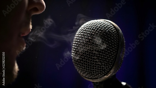 Close-up of vintage professional broadcast microphone with musician silhouette
