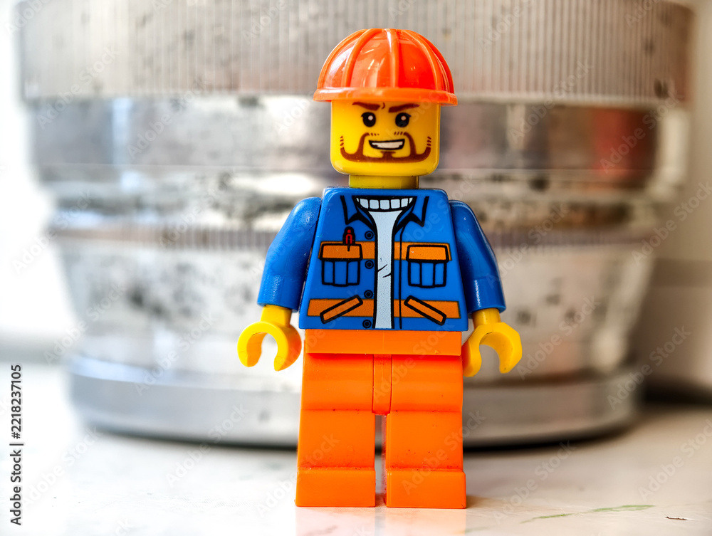 Naklejka premium Russia, St. Petersburg, August 8, 2020 A close-up of a Lego minifigure wearing a hard hat, suitable for use in illustrations related to building or construction
