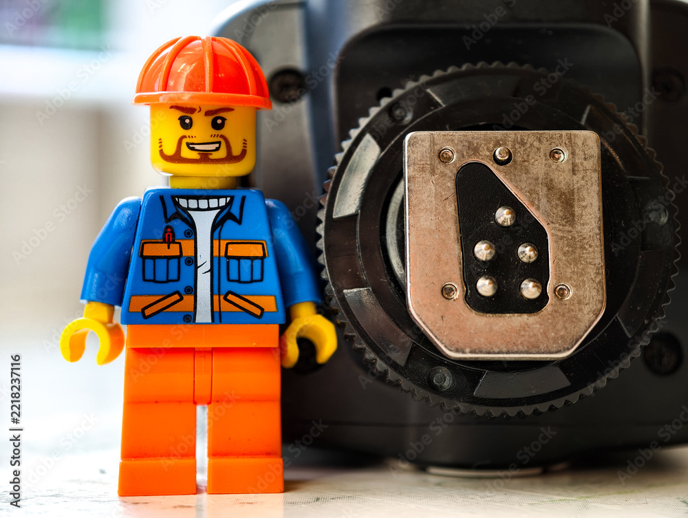 Naklejka premium Russia, St. Petersburg, August 8, 2020. Lego man standing next to flash hot shoe, creative and fun scene