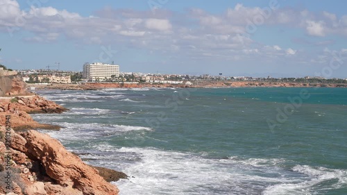 Rocky Mediterranean Coast with Waves and Coastal Resort Buildings