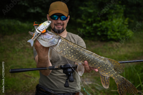 Fisherman and trophy Pike. Fishing background.