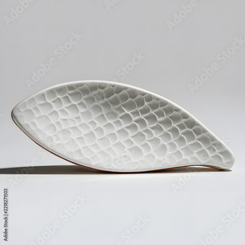 Modern white ceramic leaf shaped decorative plate with textured scale pattern on white background