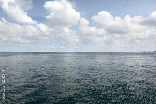 The sea, a cloudy sky, and a few islands in the distance