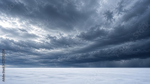 Winter storm clouds moving above empty snow plain