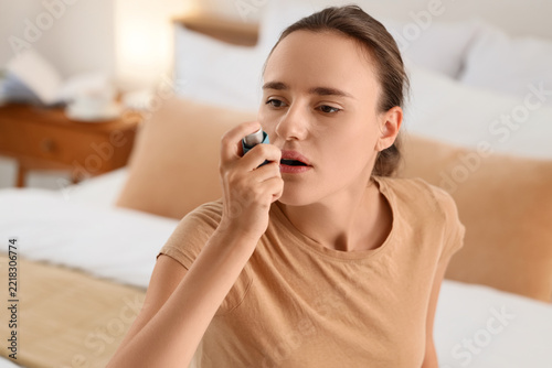 Asthma attack and respiratory health, young woman using a medical inhaler for...