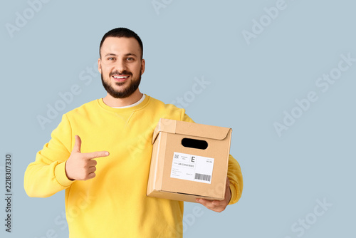 E-commerce delivery and logistics, happy man pointing at a cardboard parcel f...