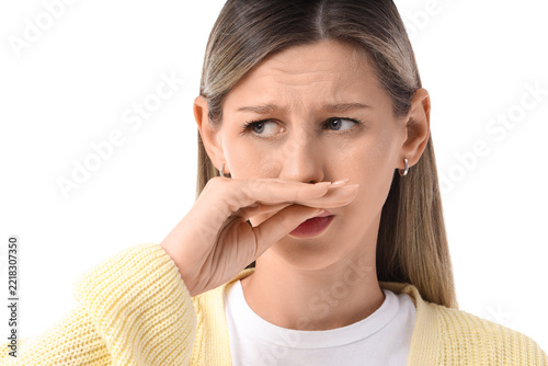 Fotografie Bad smell and disgust concept, woman covering nose with hand to block unpleasant