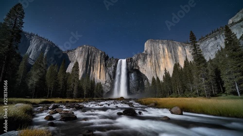 Yosemite falls flowing through granite mountains under stars