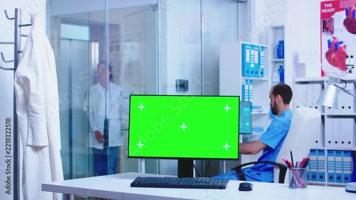 Doctor arriving in clinic behind green screen monitor