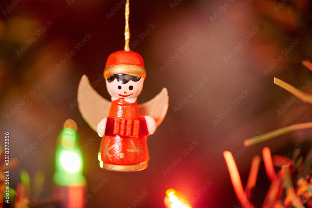 Fototapeta premium Angel, Christmas and tree with decoration closeup for December celebration or holiday season. Festive, flare and lights with Kitschmas ornament in apartment or home for cheer, joy or noel theme