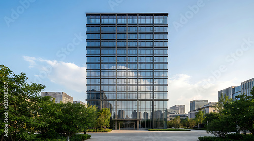 Modern glass office building with contemporary architectural design in a corporate business district under a clear blue sky