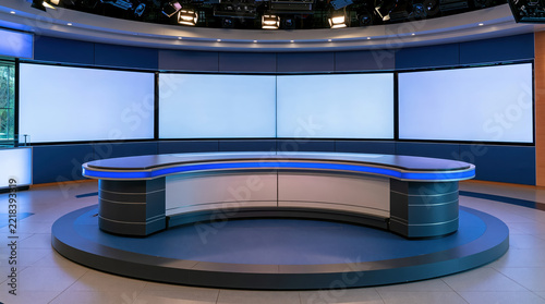 Modern empty television news studio interior with curved desk and large blank screens